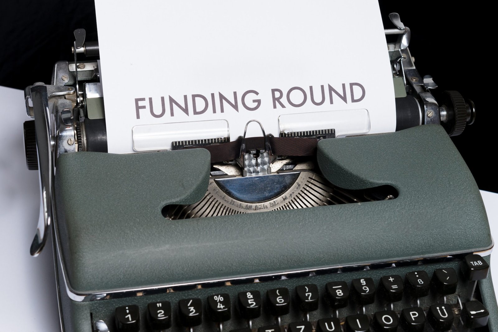 Picture of a green typewriter with the words funding round on the paper talking about business funding in South Korea.