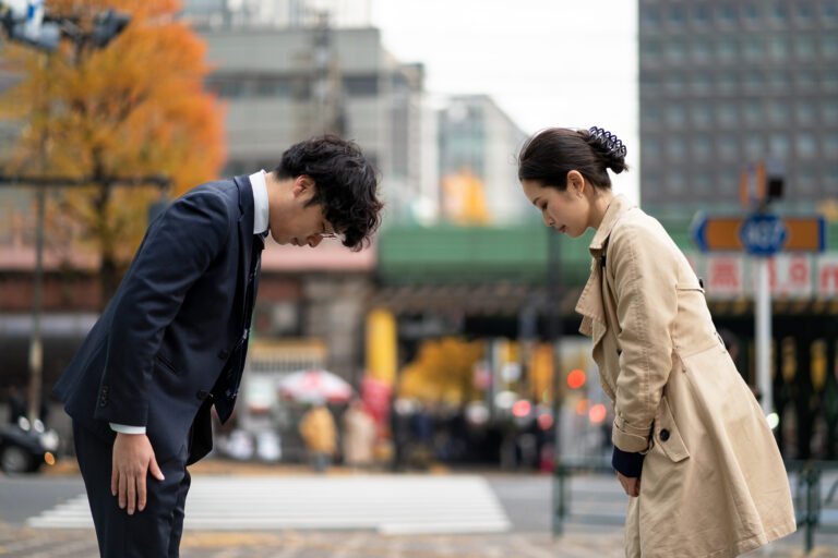 Two people bowing in a traditional way in accordance to South Korean business etiquette.